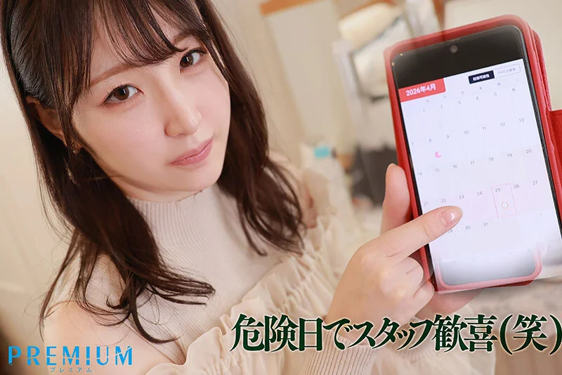 PRWF-012 小松空がベージュのニット姿でスマホの生理カレンダーアプリを指差し「危険日でスタッフ歓喜(笑)」というテロップが入るシーン